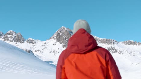 Ein-Kaukasischer-Mann-Geht-Durch-Die-Winterlandschaft-Und-Hält-An,-Um-Mit-Seiner-Kamera-Bilder-Von-Schneebedeckten-Berggipfeln-Zu-Machen