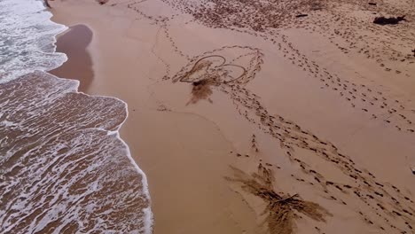 Love-heart-drawn-in-the-sand-on-beach-with-aerial-view
