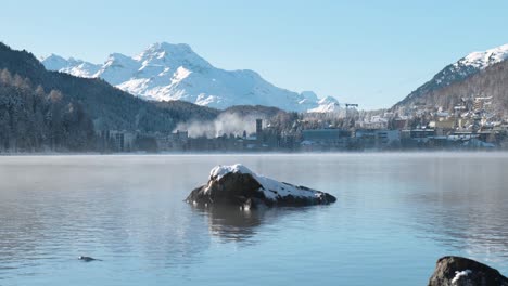 View-of-mist-and-fog-rolling-over-the-water-during-winter-on-a-lake-with-mountain-behind-in-St