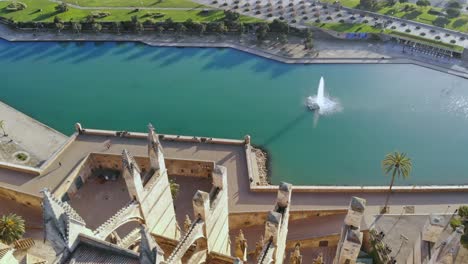 Palma-cathedral,-pond-and-road-filmed-by-drone-facing-down