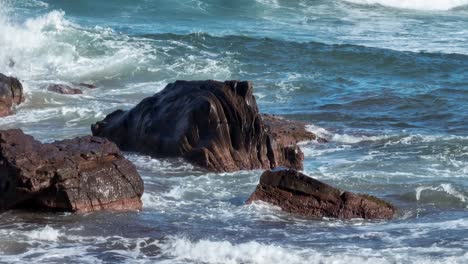 Waves-crashing-over-rocks-along-the-beach