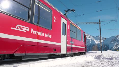 Red-panorama-train-passing-on-a-sunny-day-in-the-mountains-in-Alp-Grum,-Switzerland