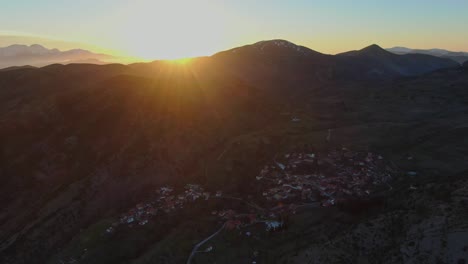 Griechisches-Dorf-Bei-Sonnenuntergang-Mit-Bergen-Im-Hintergrund