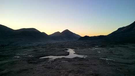 Pull-away-showing-expansive-moorland-valley-with-Loch-Caol-and-Cuillin-mountain-silhouettes-at-dawn-at-Sligachan-on-the-Isle-of-Skye-Scotland