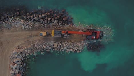 Hitachi-EX1200-Super-Long-Reach-Excavator-moves-stones-from-a-truck-into-the-sea-to-build-a-stone-breakwater
