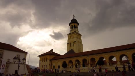 Establishing-shot-of-church-with-a-crowd-of-people-walking-infront-of-it-in-Alba-Iulia-,-Citadel-Alba-Carolina