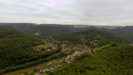 Drohnenübersicht-über-Ein-Deutsches-Dorf-An-Einem-Fluss-Mit-Wald-Und-Hügeln-In-Der-Umgebung
