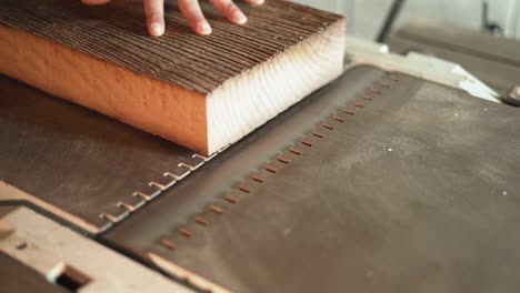 Slow-Motion-Hand-Pushing-Wood-Along-a-Tabletop-Planer