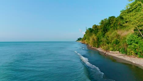 Drone-footage-of-waves-crashing-into-the-wooded-Lake-Erie-shoreline