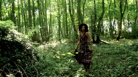 Young,-trendy-woman-in-long-dress-twirls-in-the-middle-of-a-forest