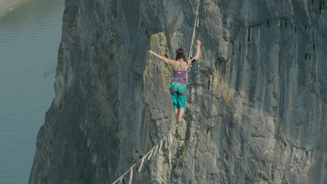 Woman-in-slack-line-high-line-over-cliff-tight-rope-walking-extreme-sport