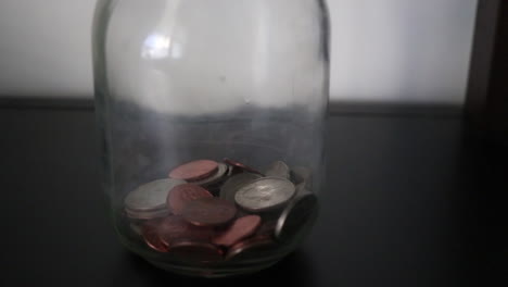 putting-coins-in-a-savings-jar