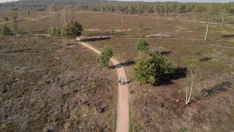 Aerial-view-of-an-elderly-couple-walking-along-a-path-through-a-moorland-landscape