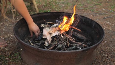 Child-feeding-twigs-to-a-small-camp-fire