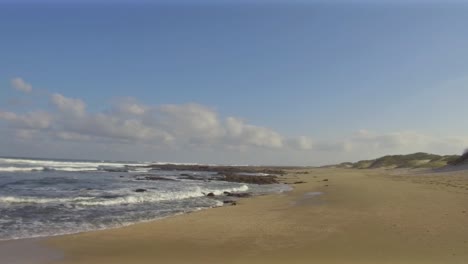 Left-to-right-pan-along-the-shoreline-of-Glen-Gariff-Beach-in-East-London,-South-Africa