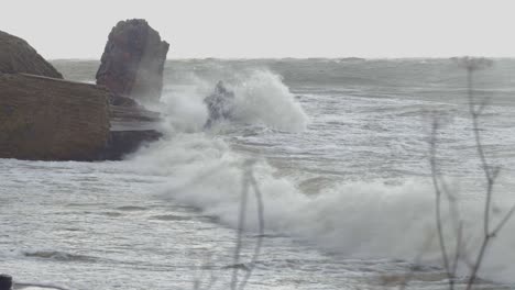 Big-waves-hitting-the-abandoned-concrete-coast-defense-building-ruins-in-stormy-weather
