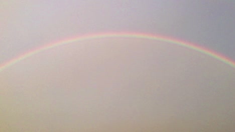 Right-to-left-wide-panning-shot-of-half-circle-double-rainbow-in-the-sky