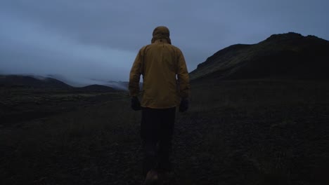 Islandia,-Persona-Caminando-A-Través-De-Un-Paisaje-Volcánico-árido-En-La-Noche,-Lente-De-Gran-Angular