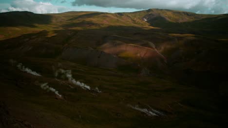 Dramatische-Isländische-Landschaft,-Aufsteigender-Geothermaler-Dampfrauch-Einer-Heißen-Quelle,-Sich-Bewegende-Wolken,-Totalaufnahme,-Zeitraffer