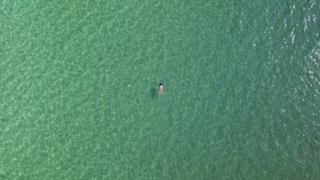 A-young-woman-in-a-bikini-swims-on-her-back-in-the-green-waters-of-the-Aegean-Sea