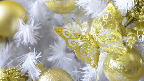 Detail-Eines-Wunderschönen-Weißen-Weihnachtsbaums,-Der-Mit-Goldenen-Schmetterlingen-Und-Kugeln-Geschmückt-Ist