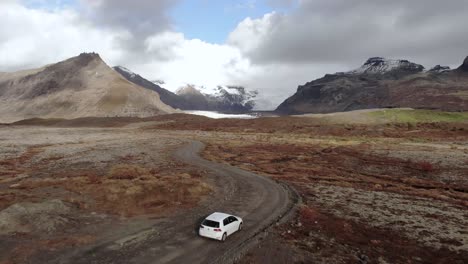 Flyover-Shot-of-a-Car-Driving-Towards-a-Glacier