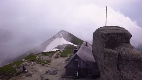 Aerial-shot-of-a-Shack-on-the-top-of-a-mountain-ridge-for-climbers-and-hikers-to-rest-for-the-night