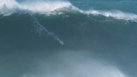Big-wave-surfer-Carlos-Burle-riding-a-monster-wave-in-Nazaré,-Portugal