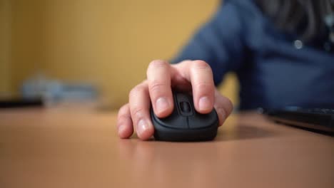 Woman-using-laptop-at-home-holding-mouse-clicking