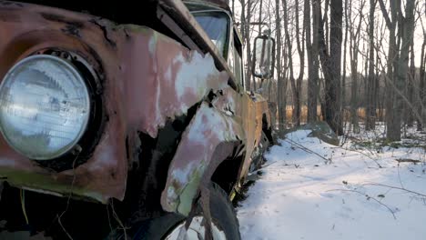 Front-of-a-Rusted-Old-Car-Weathered-and-Decaying-in-a-Snowy-Forest
