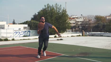 Male-basketball-player-runs-and-jumps-to-shoot-for-hoop-slow-motion-SHORT-CLIP