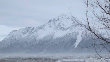 Reveal-of-Anchorage-mountains-in-Alaska-from-behind-snow-covered-car,-adventure-concept-shot-4k