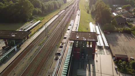 Drone-view-of-a-train-leaving-Dronten,-Flevoland,-The-Netherlands