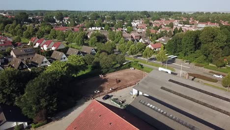 Drone-view-kids-riding-horses-in-Dronten,-Flevoland,-The-Netherlands