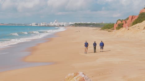 3-men-walking-along-a-beach-in-Portugal