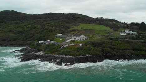 Hotel-and-restaurant-ocean-sea-coast-at-Stirling-Point,-Bluff,-New-Zealand-with---Aerial-Drone