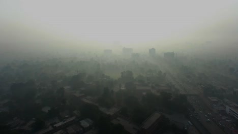 Bombay,-India,-Extreme-fog-aerial-view-over-the-city,-Showing-trees-and-a-bit-of-towers-and-a-highway-with-traffice