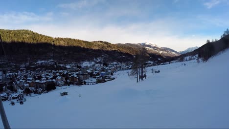 Italian-ski-resort-in-a-valley-in-winter-shot-from-a-cable-car-while-moving-away