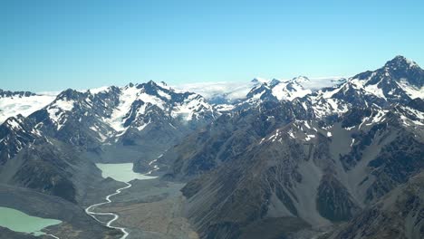 SLOWMO---Godley-river-valley-glacier-lakes-with-snow-capped-rocky-mountains-in-Aoraki-Mount-Cook-National-Park,-Southern-Alps,-New-Zealand-from-airplane-scenic-flight