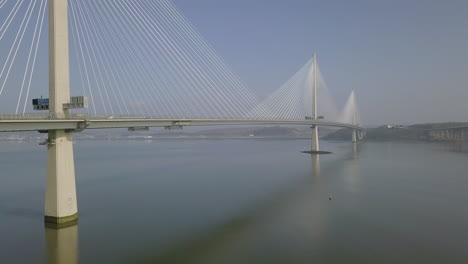 Aerial-footage-of-traffic-travelling-across-the-Queensferry-Crossing-bridge-at-South-Queensferry-on-a-sunny-day-in-West-Lothian,-Scotland