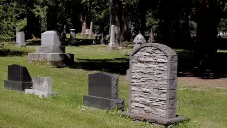 Custom-unique-stone-tombstone-in-grassy-graveyard-cemetery