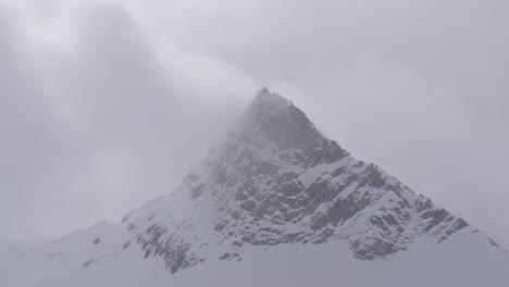 Wind-whipping-over-rocky-mountain-summit-in-winter
