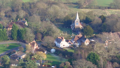 Aerial-pullback-from-St-Marys-church-in-High-Halden-village,-located-in-Kent-UK-to-reveal-the-British-countryside