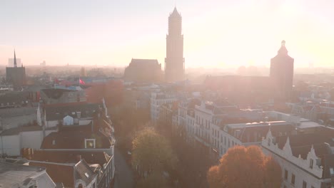 Luftaufnahme-Des-Historischen-Zentrums-Der-Stadt-Utrecht-In-Den-Niederlanden-Mit-Dem-Von-Sonnenlicht-Durchfluteten-Horizont,-Der-Den-Silhouettierten-Kirchturm-Zeigt,-Der-Sich-Hoch-über-Der-Stadt-Erhebt