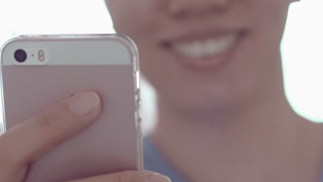 Junge-Asiatische-Frau-Lächelt,-Wenn-Sie-Ihr-Smartphone-Benutzt
