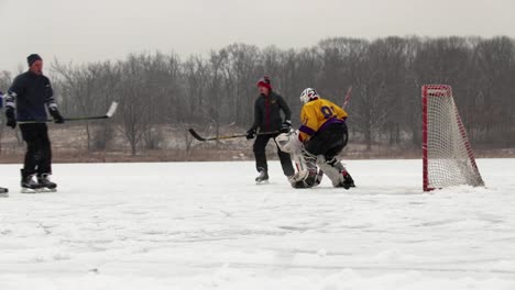 A-slow-motion-of-a-teenager-scoring-a-goal-during-their-pond-hockey-game