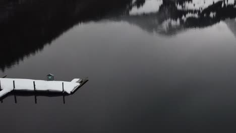 Flying-backwards-very-close-to-the-water-and-over-the-ice-past-a-raft-on-a-mountain-lake