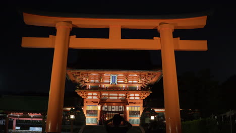 Wide-view-of-the-front-gate-area-of-the-Fushimi-Inari-Shrine-at-night-in-Kyoto,-Japan