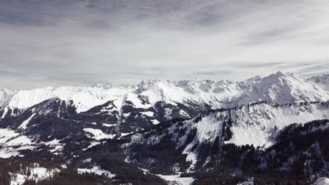 Aerial-drone-shot-on-montains-in-the-alps,-Austria,-Kleinwalsertal,-skiing-area,-snowy-mountains