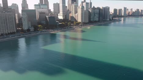 Aerial-reveal-of-Hancock-and-Chicago-lakefront-with-busy-traffic-in-a-beautiful-weather